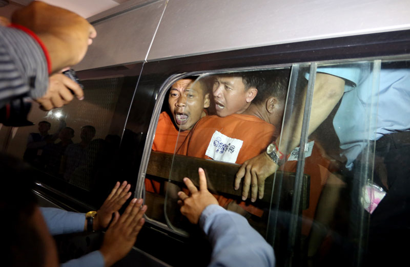 Vorn Pao, center, president of the Independent Democracy of Informal Economy Association, yells to journalists as he and other defendants are driven away from the Phnom Penh Municipal Court on Friday. He and 22 others were tried for their roles in garment strikes that turned violent in January. (Siv Channa)