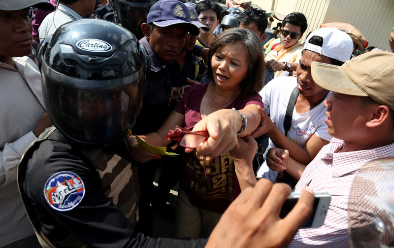 CNRP lawmaker-elect Mu Sochua faces off with Daun Penh district security guards after being forced out of Phnom Penh's Freedom Park on Thursday. (Siv Channa)