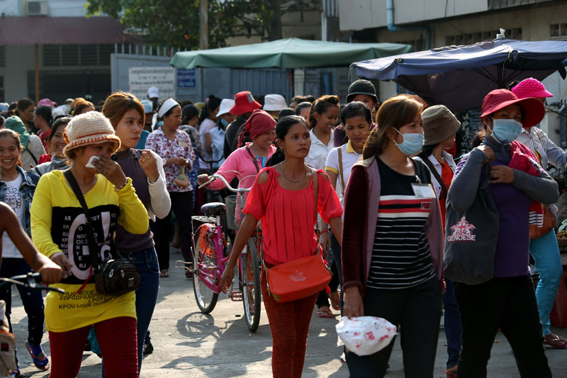 Garment workers leave the Hoyear factory in Phnom Penh's Meanchey District at the end of their shift Monday. (Siv Channa)