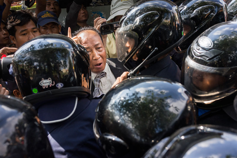 Daun Penh district security guards block Beehive Radio station owner Mam Sonando from marching to the Ministry of Information on Monday to protest the government's repeated rejection of his request for a TV license and radio relay towers. (John Vink/Magnum Photos)