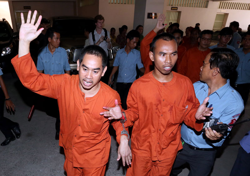 Thach Kongphuong, left, and Yorn Kimsrun, remonstrate after they and five other men were imprisoned for plotting to overthrow the government in an emotionally charged trial in Phnom Penh Municipal Court on Friday. Six other people were also sentenced in absentia. (Siv Channa)