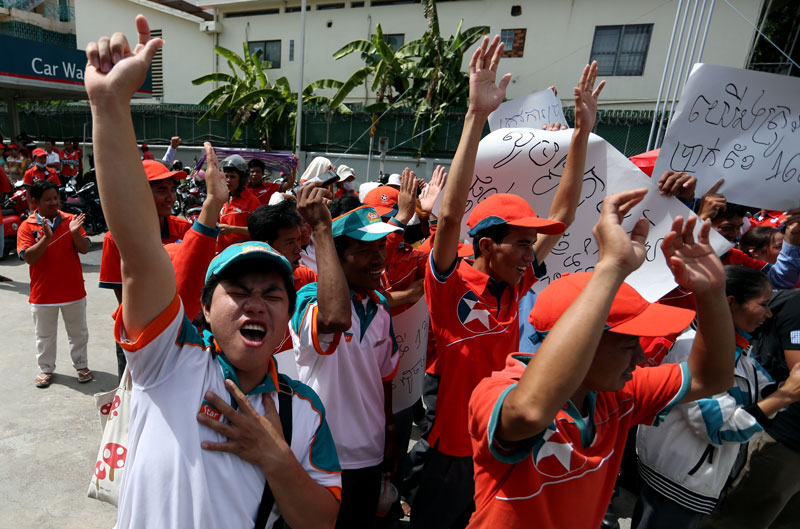Striking Caltex workers cheer during a demonstration Wednesday at the Caltex Bokor station on Monivong Boulevard in Phnom Penh calling for a higher salary and an annual bonus. (Siv Channa)