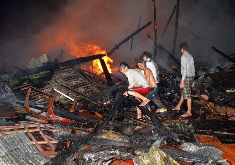 Meanchey district villagers battle a fire that destroyed 22 homes in the early hours of Wednesday morning. (Alex Consiglio/The Cambodia Daily)