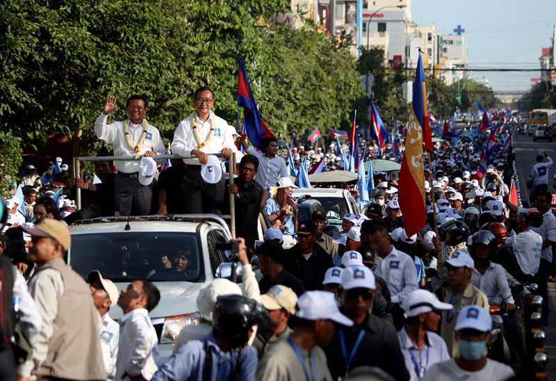 CNRP leaders Sam Rainsy, right, and Kem Sokha head a march of thousands up Monivong Boulevard on Friday, the final day of campaigning for the municipal, provincial and district council elections. (Siv Channa)