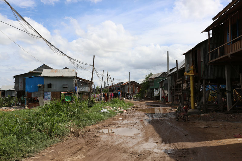 Stilt houses line the muddy road that runs through Boeng Tompun commune. (Kayle Hope/The Cambodia Daily)