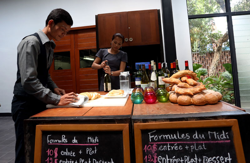 Phang Vathana, left, and Nop Sangvaleaph at work in Le Bistro, the Institut Francais restaurant that opened in late March. (Siv Channa)