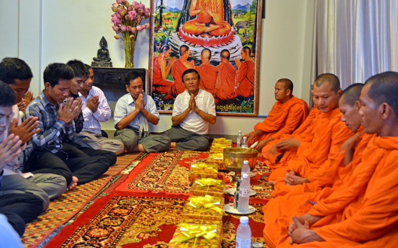 Labor leader Vorn Pao, center left, and CNRP leader Kem Sokha, center right, take part in a traditional Buddhist ceremony Sunday at Mr. Sokha's Phnom Penh residence. (Alex Consiglio/The Cambodia Daily)
