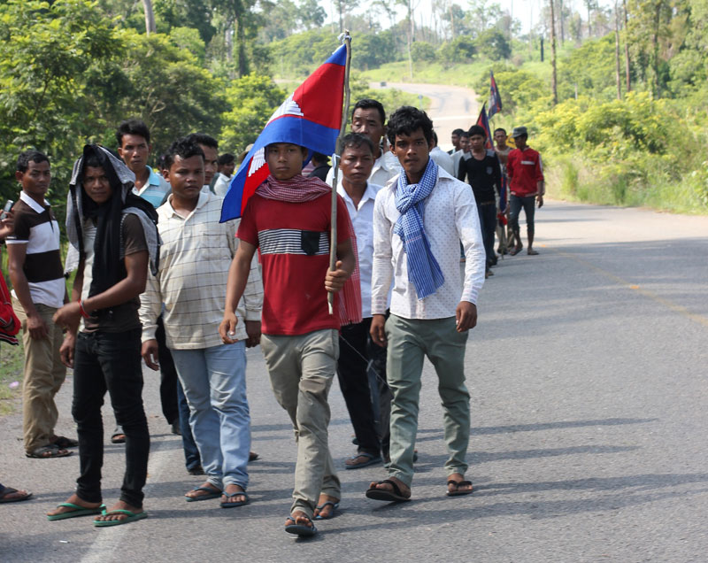 A group of men wait Sunday morning alongside a roadblock on Road 67, where CNRP leaders were supposed to travel on their way to Oddar Meanchey province's Anlong Veng district. (Alex Willemyns/The Cambodia Daily)