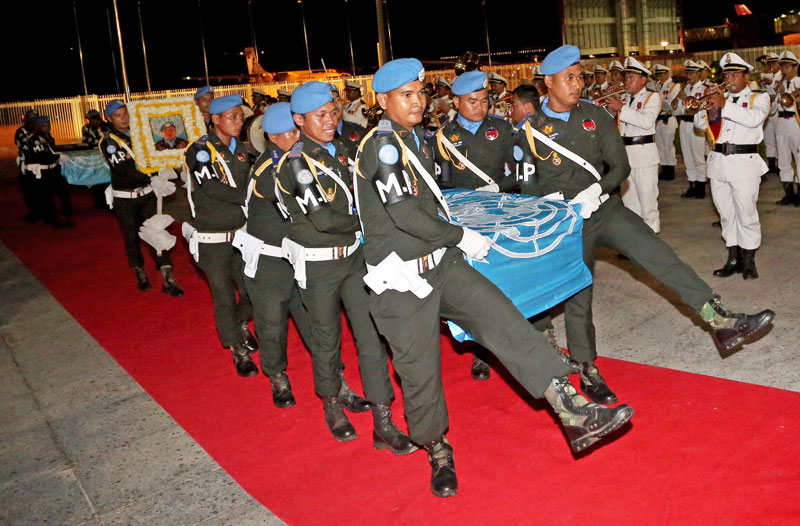 At a repatriation ceremony at the Phnom Penh International Airport on Wednesday, military police carry the coffins of two soldiers who died June 10 on a UN peacekeeping mission in Mali. The reason given for the peacekeepers' deaths was food poisoning, though no autopsy has been performed on the bodies. (Siv Channa/The Cambodia Daily)