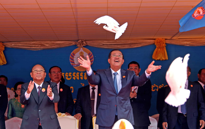 National Assembly President Heng Samrin, left, and Prime Minister Hun Sen, right, release doves Saturday during a celebration of the 63rd anniversary of the founding of the Kampuchean People's Revolutionary Party, whose name was resurrected after the fall of the Khmer Rouge by the leaders of today's Cambodian People's Party. (Siv Channa/The Cambodia Daily)