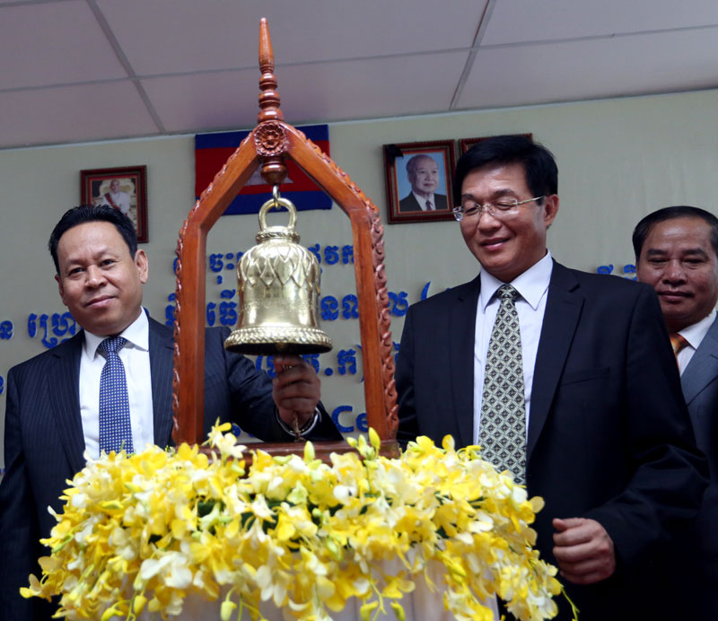 Hean Sahib, left, chairman of the Cambodia Securities Exchange, and Eddie Liao, CEO and director of the Grand Twins garment factory, ring the bourse's opening bell Monday at 9 a.m. (Siv Channa/The Cambodia Daily)