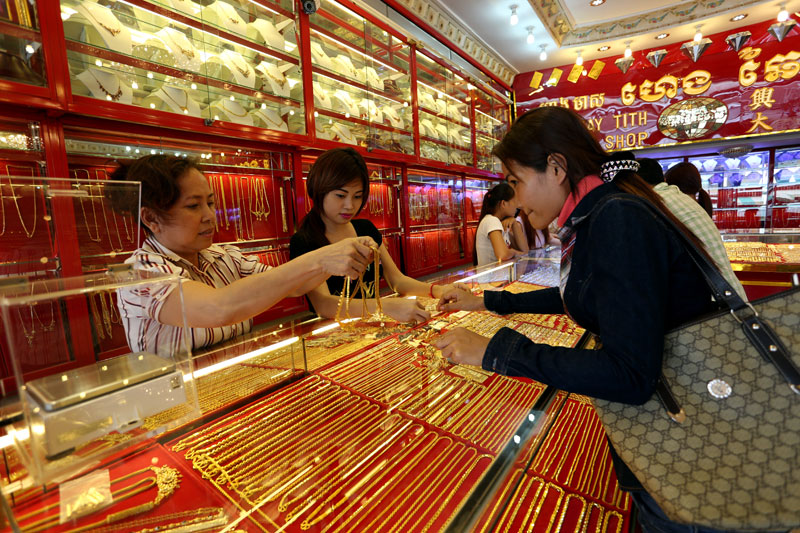 A gold vendor shows necklaces to a customer Wednesday at Heng Chhay Tith Jewelry Enterprise in Phnom Penh. (Siv Channa/The Cambodia Daily)