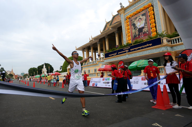 Hem Bunting crosses the finish line outside the Royal Palace as he wins the 4th annual Phnom Penh International Half Marathon on Sunday. (Siv Channa/The Cambodia Daily)