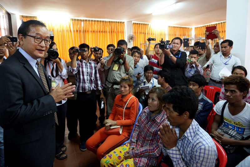 CNRP President Sam Rainsy speaks to reporters during a press conference attended by 51 migrant workers who fled Thailand and were transported from Poipet City to Phnom Penh by the opposition party. (Siv Channa/The Cambodia Daily)