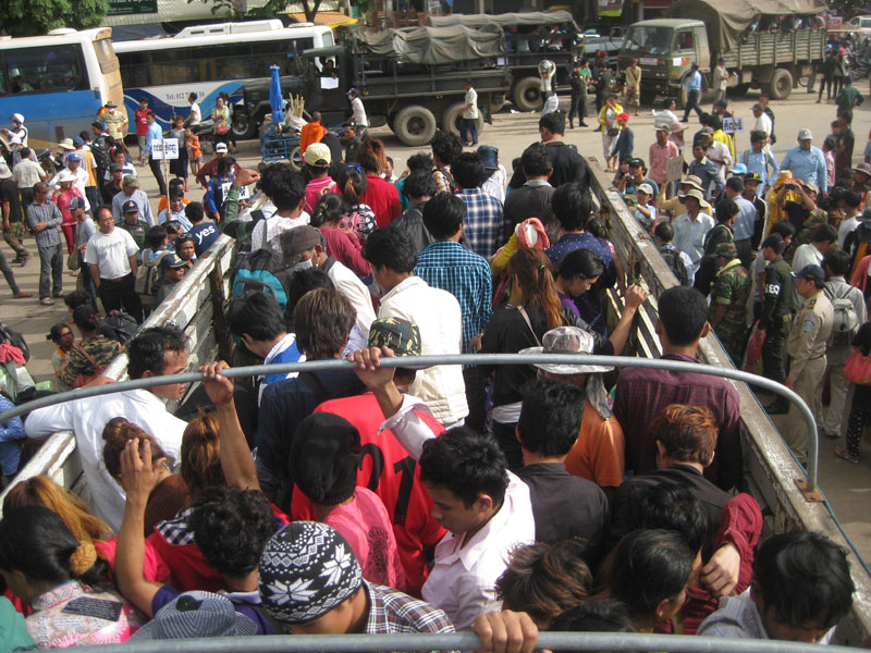 Around 100 workers disembark from a truck in Poipet City on Monday after leaving Thailand amid mounting fears of the military junta that seized power there late last month. (Saing Soenthrith/The Cambodia Daily)