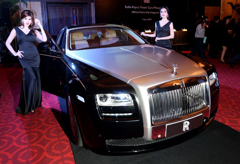 Models on Monday stand beside the Rolls-Royce Ghost, a $450,000 car that will be available in Cambodia once construction of the company's showroom is complete later this year. (Siv Channa)