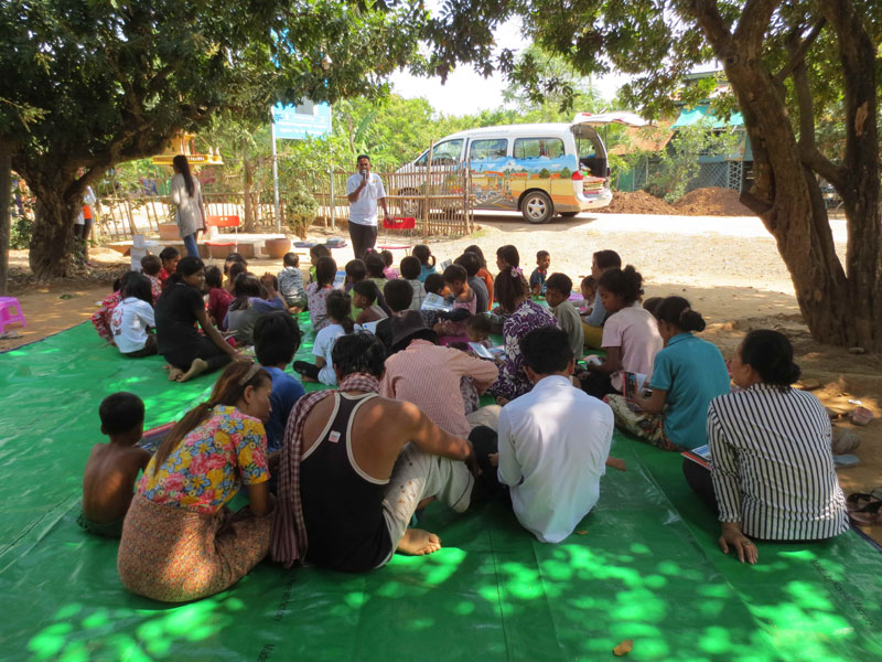Villagers sit in front of a mobile library operated by the literacy NGO Sipar. (Sipar)