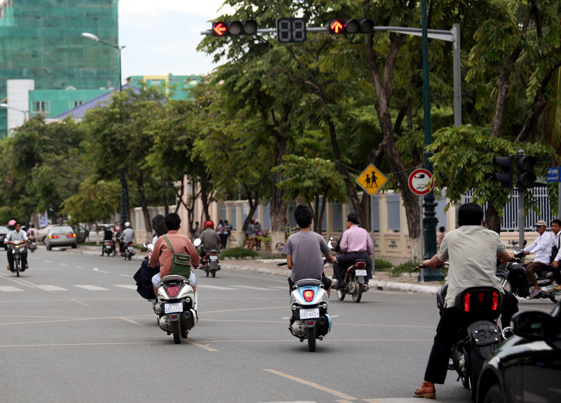 Motorbike drivers ignore a red light at an intersection on Norodom Boulevard on Wednesday in Phnom Penh. (Siv Channa/The Cambodia Daily)