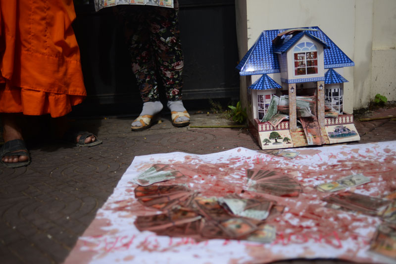 A cardboard house and piles of 'ghost money' were covered in chicken blood Monday by land rights protesters outside the World Bank office in Phnom Penh. (Lauren Crothers/The Cambodia Daily)