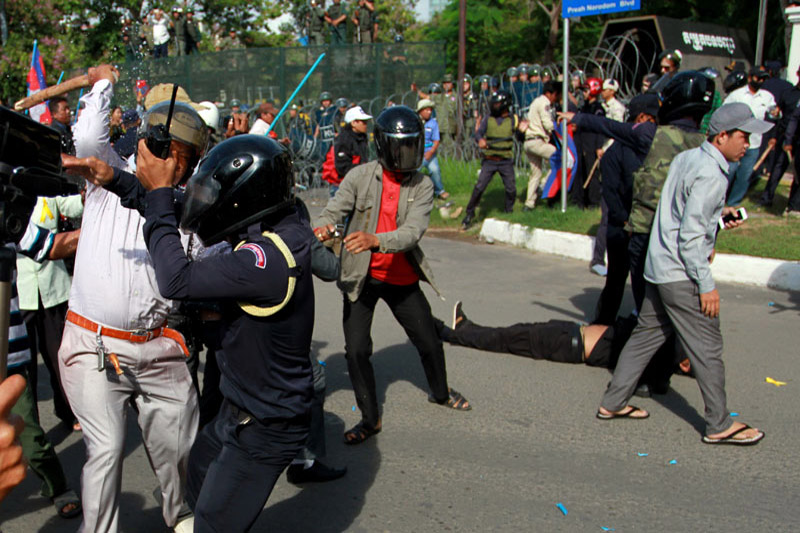 A man beats a Daun Penh district security guard Tuesday near Freedom Park. (Siv Channa/The Cambodia Daily)