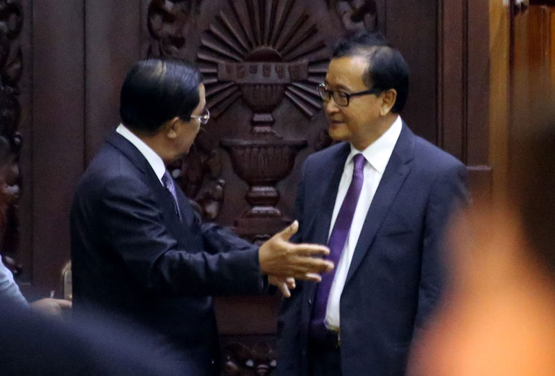 Prime Minister Hun Sen and CNRP President Sam Rainsy speak in the National Assembly on Monday after a special session called to validate Mr. Rainsy's ascension to the CNRP's list of incoming lawmakers-elect. (Siv Channa/The Cambodia Daily)