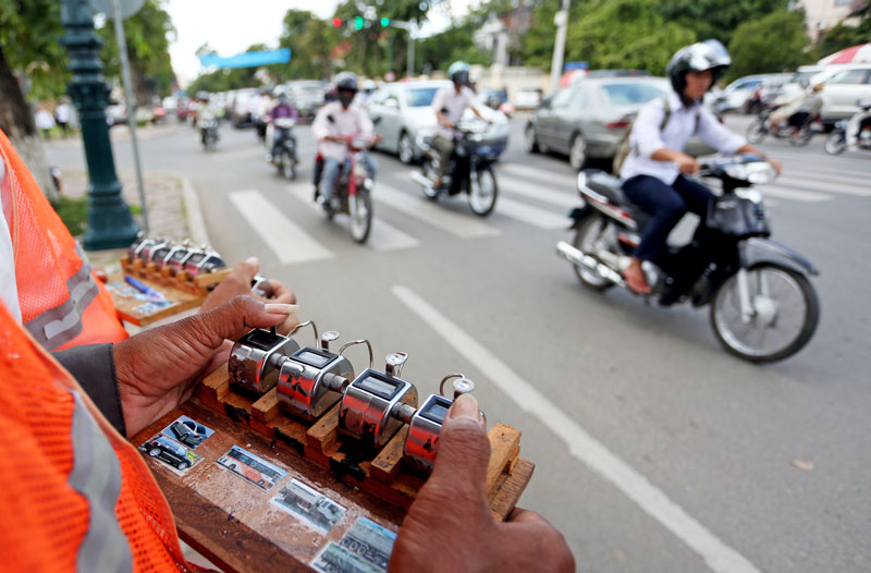 Surveyors count vehicles at the intersection of Norodom Boulevard and Street 214 in Phnom Penh on Wednesday, the first stage of a new study to improve the city's traffic light system. (Siv Channa/The Cambodia Daily)