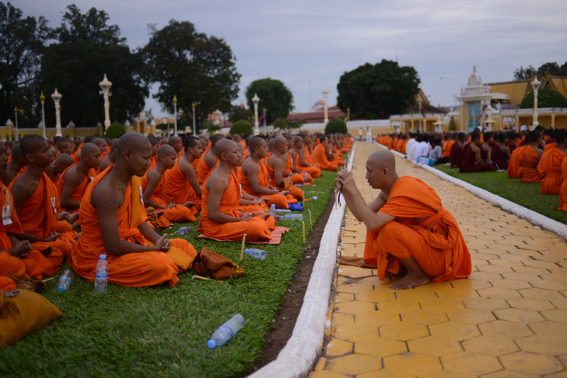 Monks snap photos of CNRP Vice President Kem Sokha following a ceremony outside the Royal Palace Wednesday evening. (Siv Channa/The Cambodia Daily)