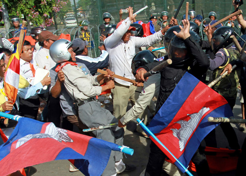 Opposition protesters and Daun Penh district security guards fight near Freedom Park in Phnom Penh on Tuesday during a protest against the closure of the park led by CNRP public affairs director Mu Sochua. (Siv Channa/The Cambodia Daily)