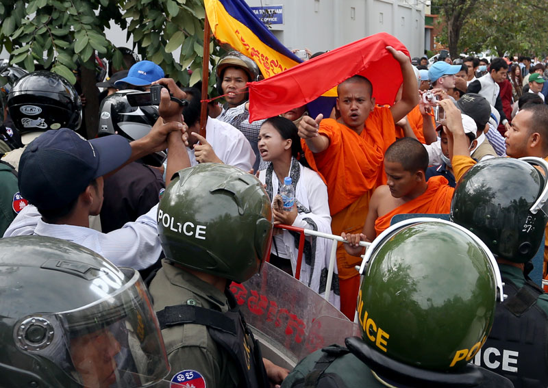 Ethnic Khmer Krom monks and civilian demonstrators jeer at riot police at a roadblock near the Vietnamese Embassy in Phnom Penh on Tuesday. (Siv Channa/The Cambodia Daily)