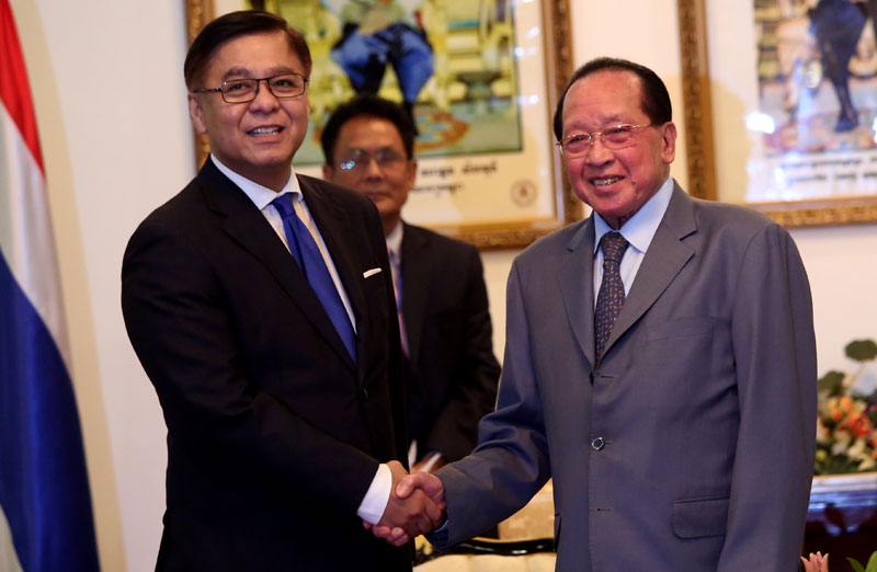 Sihasak Phuangketkeow, left, acting foreign minister under the Thai junta, shakes hands with Foreign Minister Hor Namhong at the Ministry of Foreign Affairs in Phnom Penh on Tuesday. (Siv Channa/The Cambodia Daily)