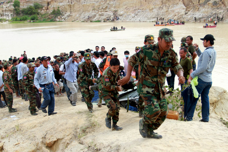 Royal Cambodian Armed Forces soldiers carry the body of one of the four military personnel killed in a helicopter crash in Phnom Penh on Monday morning. (Siv Channa/The Cambodia Daily)