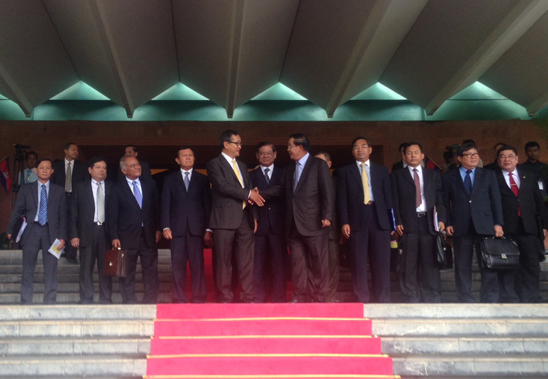 Opposition leader Sam Rainsy, left center, shakes hands with Prime Minister Hun Sen after the parties finalized an agreement Tuesday to end the country's nearly yearlong political deadlock. (Alex Willemyns/The Cambodia Daily)