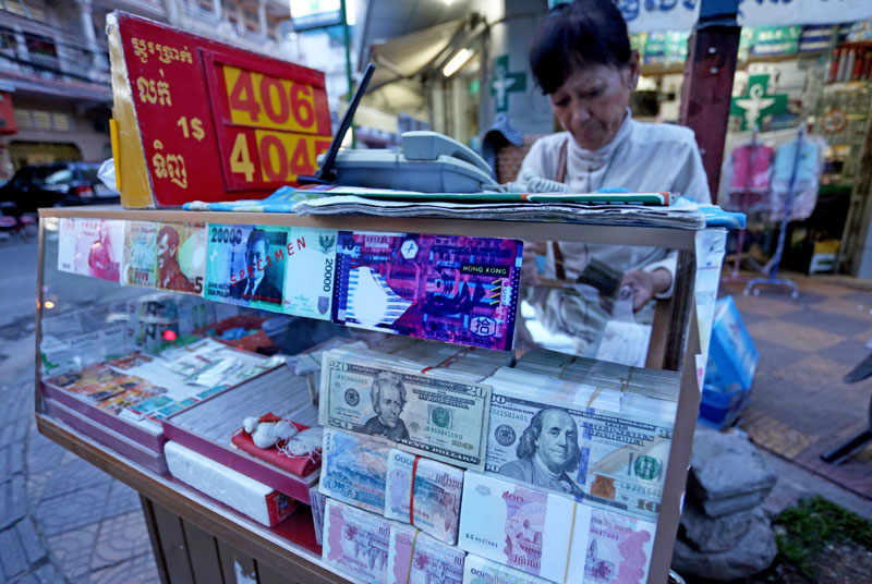 Khut Phany, 57, closes her money exchange stall Thursday evening on Street 284. (Siv Channa/The Cambodia Daily)