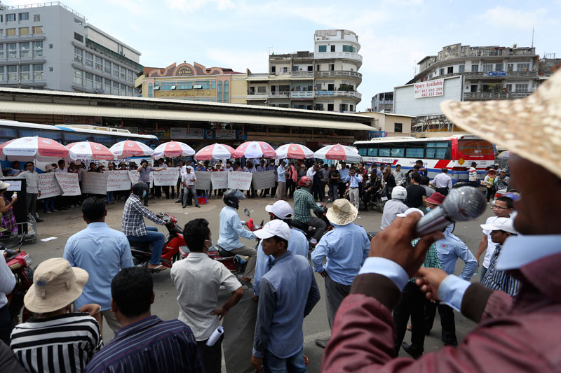 Employees of the Phnom Penh Sorya Transportation company stage a counterprotest outside the firm's bus station Tuesday against 17 sacked bus drivers, who have joined unionists in five months of protests to demand their jobs back. (Siv Channa/The Cambodia Daily)