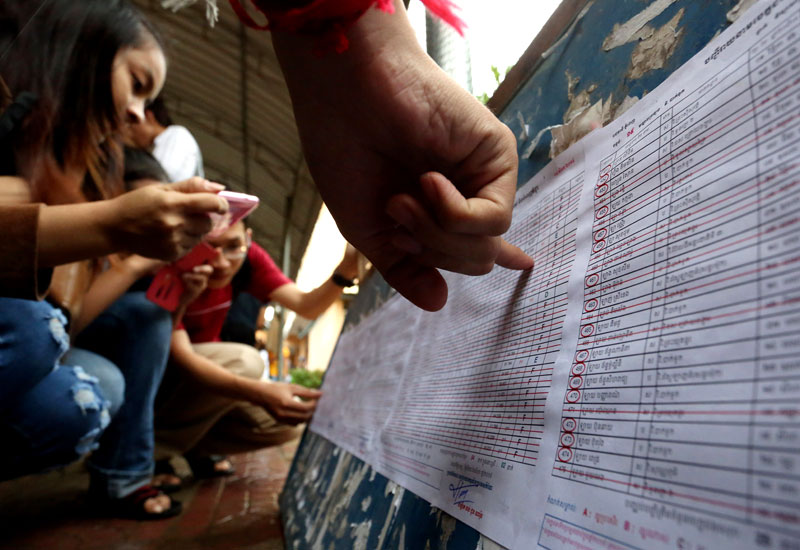Students at Bak Touk High School in Phnom Penh check the notice board for their results in the 2014 high school national exam. (Siv Channa/The Cambodia Daily)