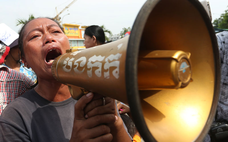 Oum Sophy, a representative of villagers embroiled in a land dispute in Kompong Chhnang province, protests in Phnom Penh with a megaphone borrowed from the Boeng Kak community. (Siv Channa/The Cambodia Daily)