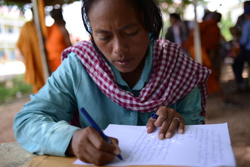 Lor Peang village representative Oum Sophy drafts a petition letter at a school in Phnom Penh's Russei Keo district Wednesday. (Lauren Crothers/The Cambodia Daily)