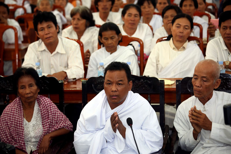 Thean Vuthy, flanked by his supporters, appears on Thursday in front of senior Buddhist clergy and the minister of cults and religion at Kandal's provincial offices. (Siv Channa/The Cambodia Daily)