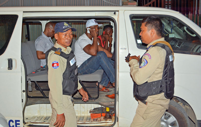 Immigration police detain a group of foreigners last night in Boeung Tompun commune. (Alex Consiglio/The Cambodia Daily)