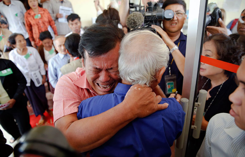 Soum Rithy, center, who lost his father and three siblings during the Khmer Rouge regime, breaks out in tears and hugs another survivor after the verdict was delivered in the trial of former Khmer Rouge leaders Thursday morning. (Reuters)