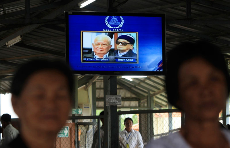 Former Khmer Rouge head of state Khieu Samphan, left, and ''Brother Number Two'' Nuon Chea are shown on a television screen Thursday outside the Extraordinary Chambers in the Courts of Cambodia. (Reuters)