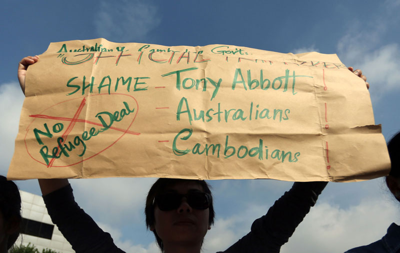A protester holds up a sign Friday outside the Australian Embassy in Phnom Penh. (Siv Channa/The Cambodia Daily)