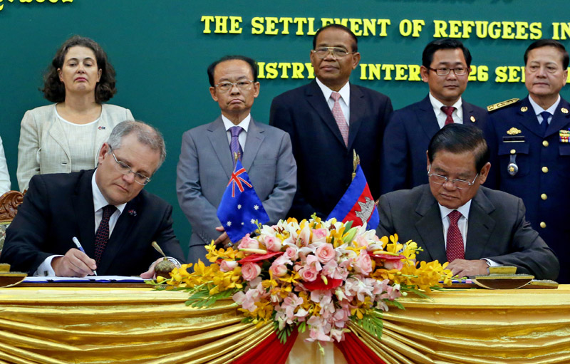 Australian Immigration Minister Scott Morrison, left, and Cambodian Interior Minister Sar Kheng sign a deal at the Interior Ministry on Friday that will see refugees currently being held on the South Pacific island of Nauru resettled in Cambodia. (Siv Channa/The Cambodia Daily)