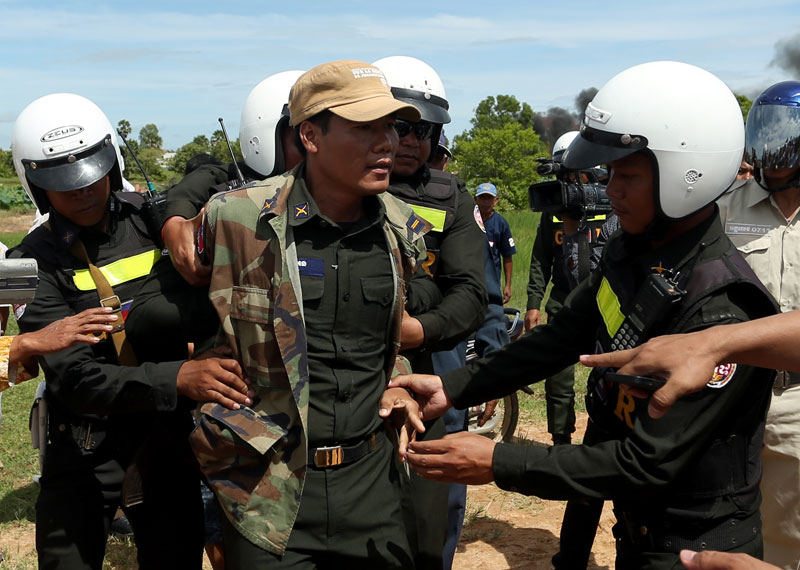 Military police restrain their colleague Ung An during a scuffle Wednesday at the site of a land dispute in Phnom Penh's Pur Senchey district between 68-year-old Huot Sarom and 120 families who sold the land to Dy Proem, a cousin of Prime Minister Hun Sen. (Siv Channa/The Cambodia Daily)