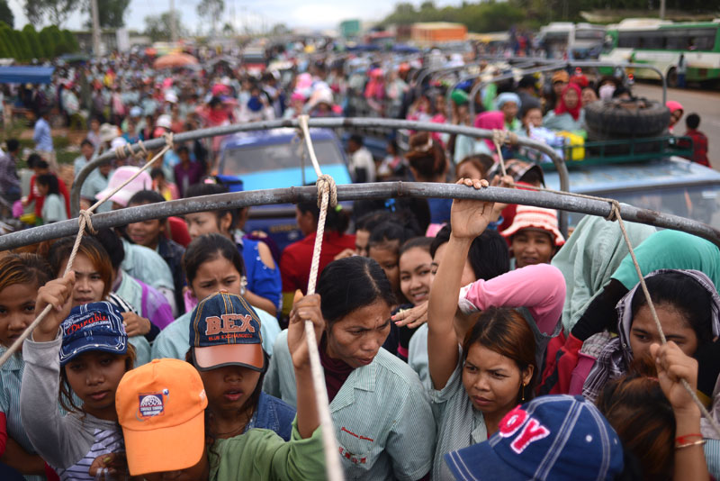 Garment workers pile into trucks in Kompong Speu province in July. (Lauren Crothers/The Cambodia Daily)