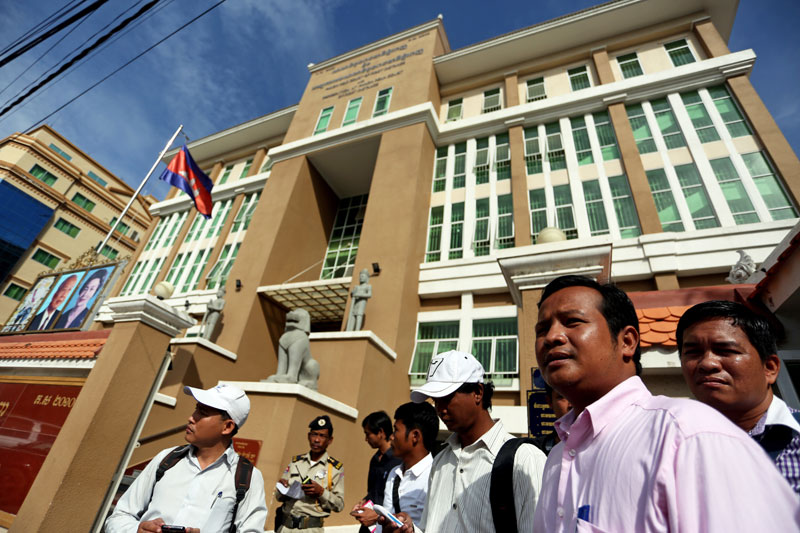 Union leader Pav Sina, second from right, stands in front of the Phnom Penh Municipal Court on Friday ahead of being questioned over his alleged role in garment sector protests in December and January that turned violent before being lethally suppressed by military police. (Siv Channa/The Cambodia Daily)
