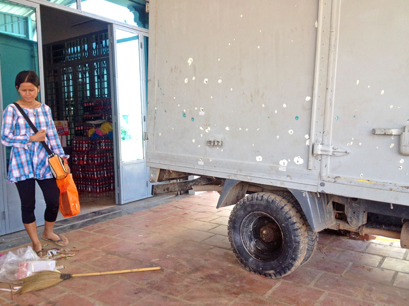 Sin Theavy stands near her truck, which is pocked with holes made by shrapnel from a grenade thrown at her family last week at their home in Phnom Penh's Sen Sok district. (Alex Consiglio/The Cambodia Daily)
