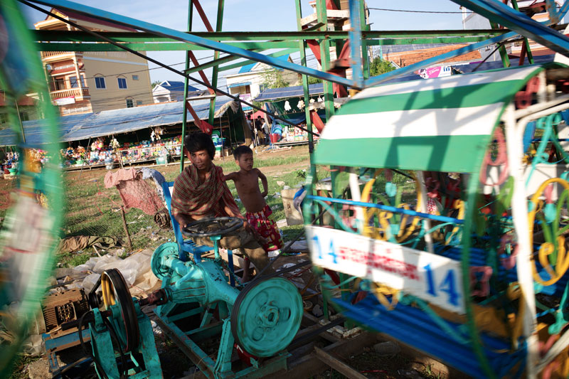 A Ferris wheel operator watches on as customers take a ride. (Ben Woods/The Cambodia Daily)