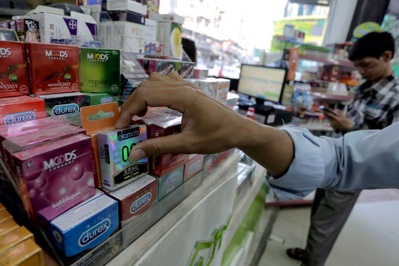A man reaches for a box of condoms at a convenience store in Phnom Penh on Wednesday. (Siv Channa/The Cambodia Daily) 