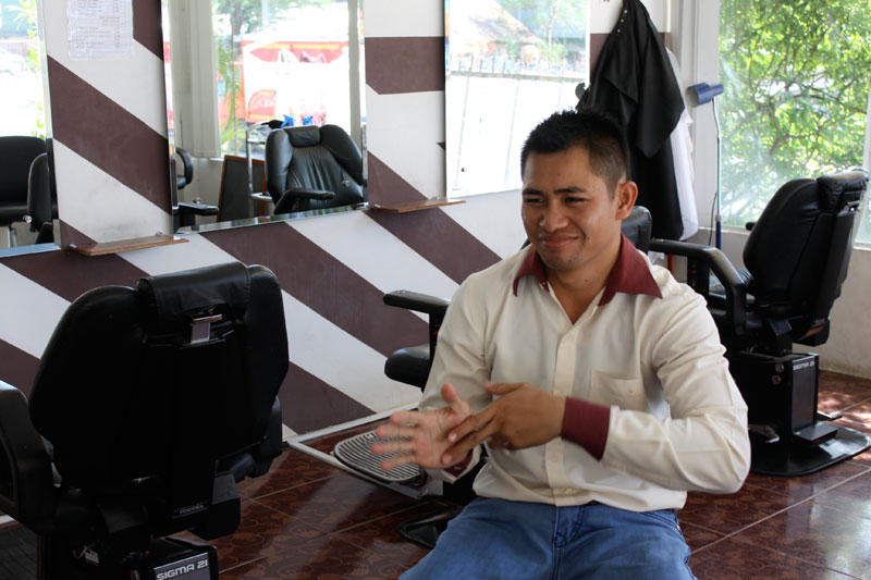 Deaf barber 'F4' describes what he can remember of his past through a sign language interpreter at Dr. Hair salon in Phnom Penh's Tuol Kok district last month. (Holly Robertson/The Cambodia Daily)